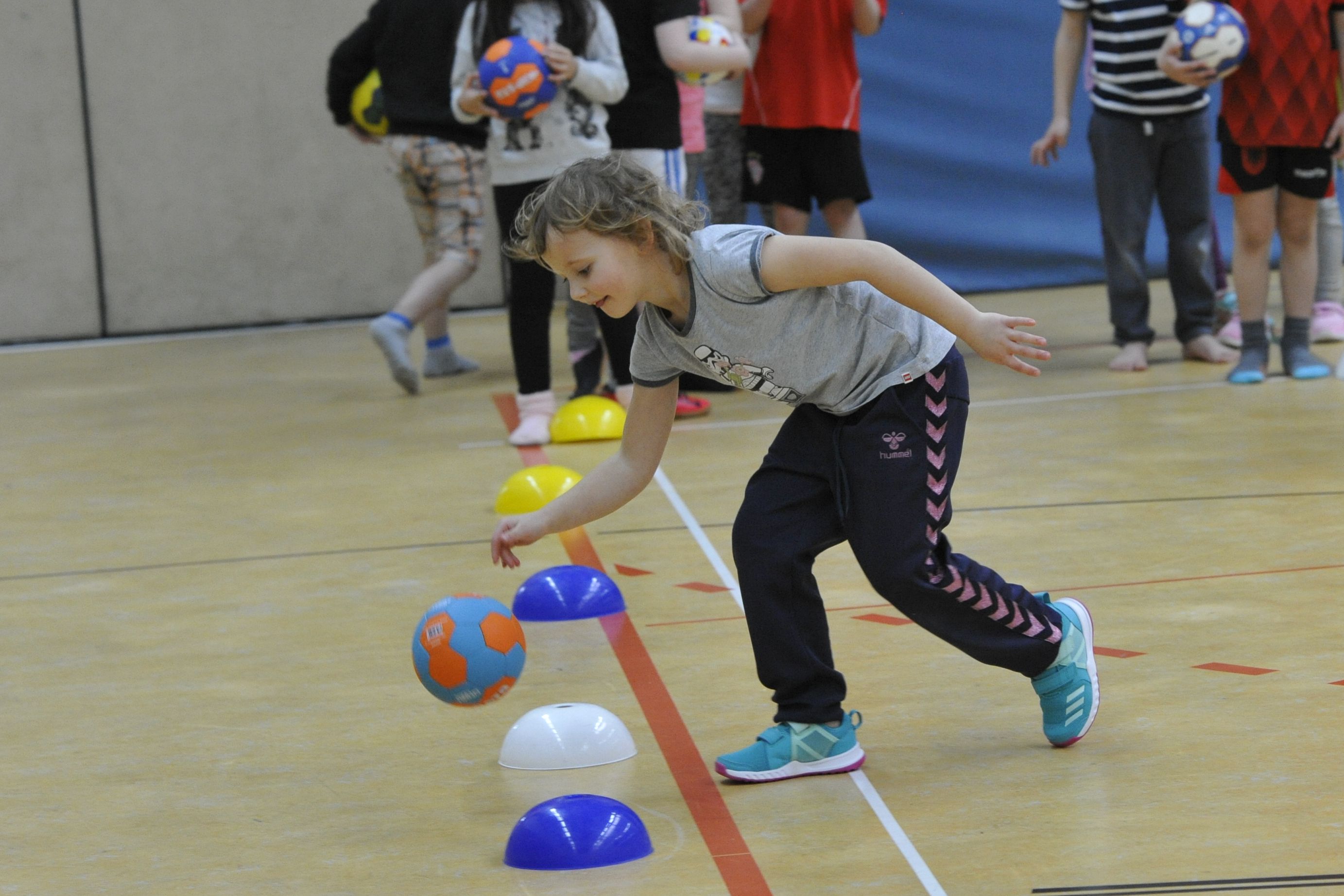 Kind übt Prellen mit dem Handball