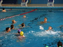 Damian Wierling schwimmt mit Kindern im Wasser