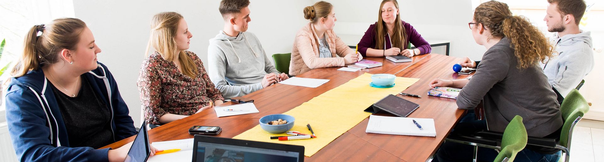 Jugendliche beraten sich an einem Tisch