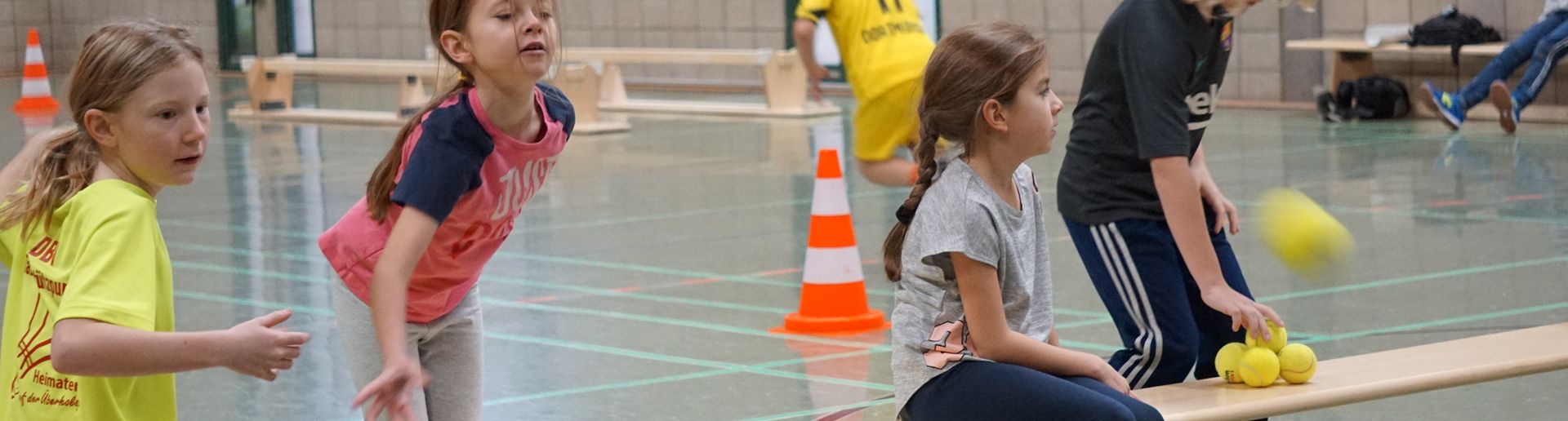 Kinder versuchen mit einem Ball etwas zu treffen
